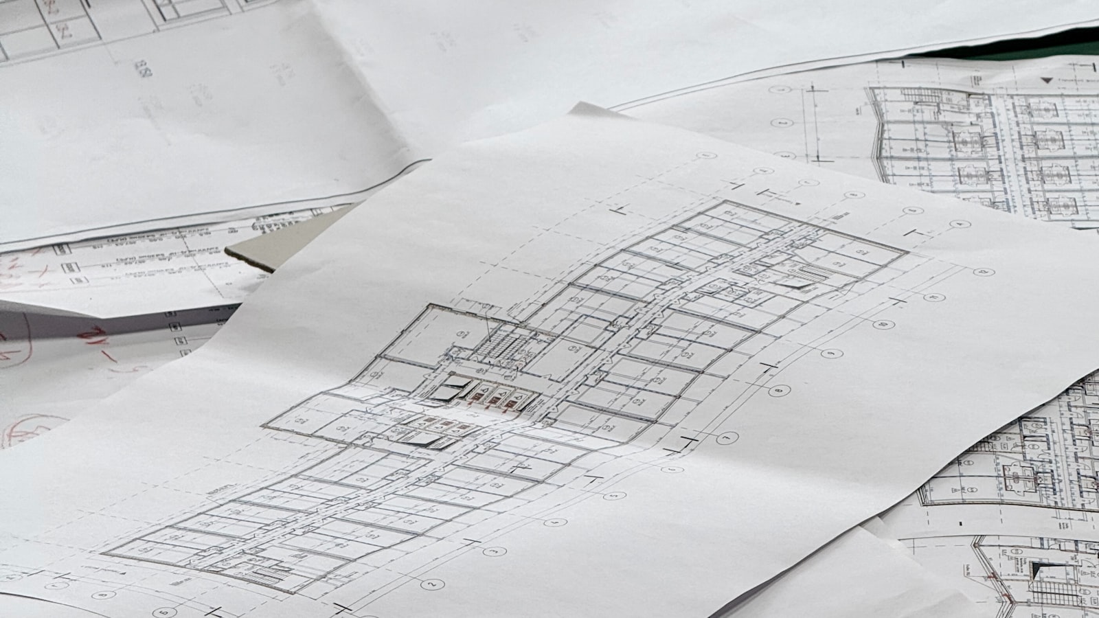 Architectural floor plans spread loose across a work table